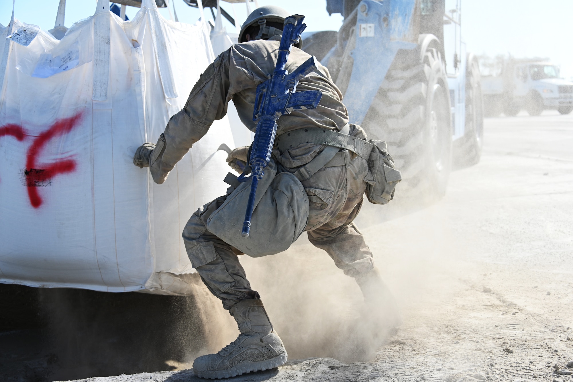 Photo of Airman cutting open bag of cement.