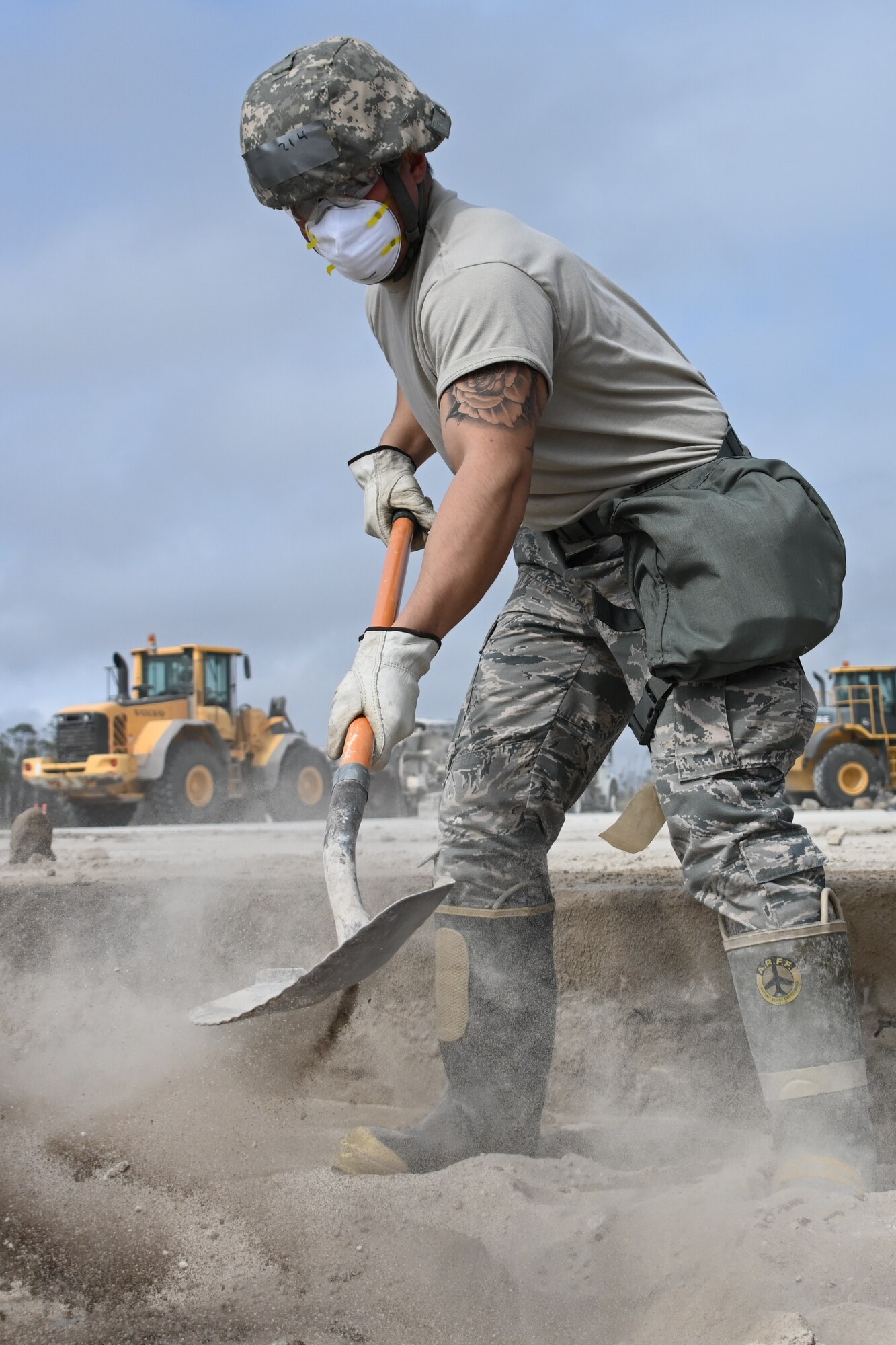 Photo of Airman shoveling concrete.