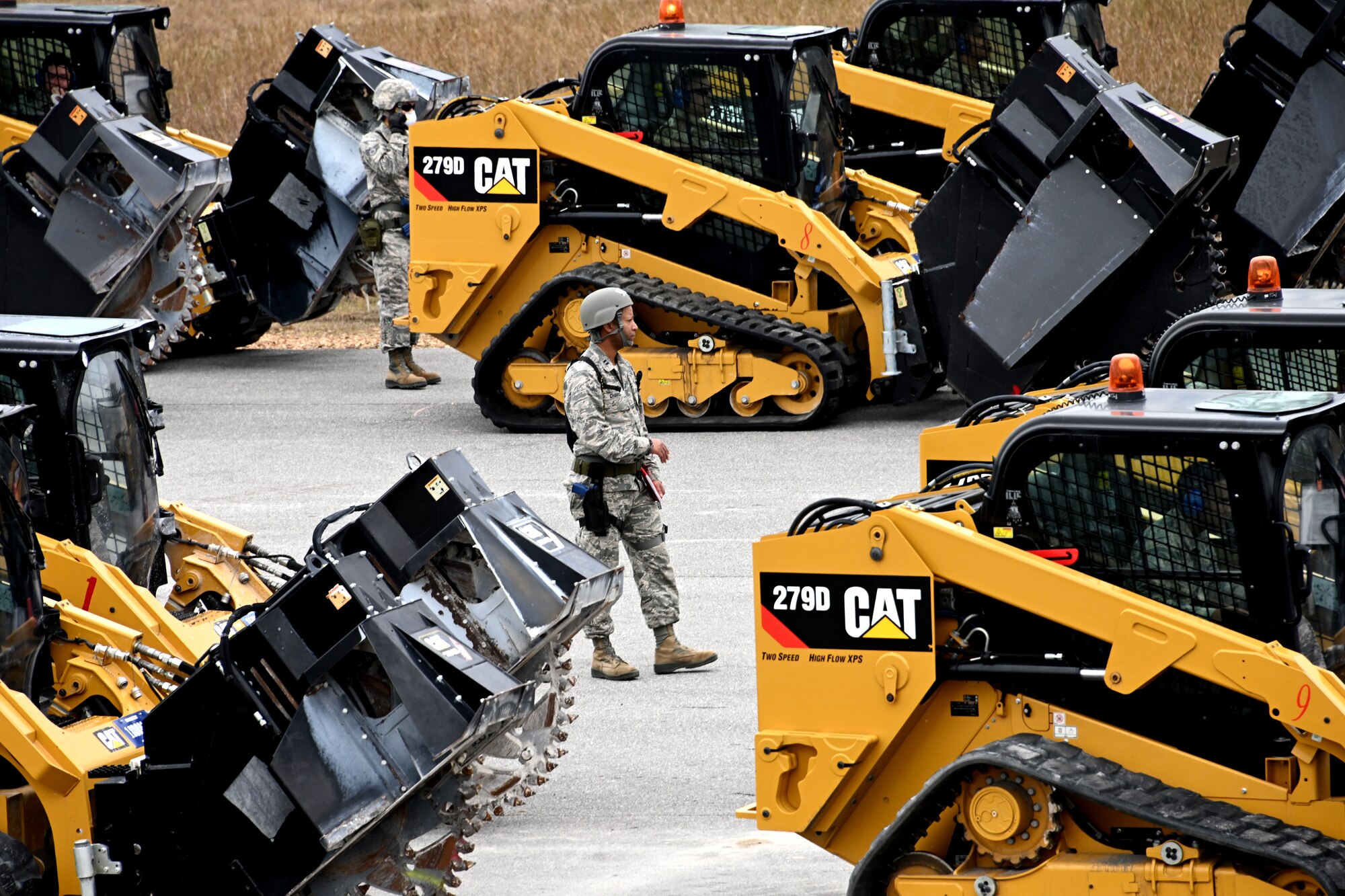 Photo of Airman walking among heavy equipment vehicles.