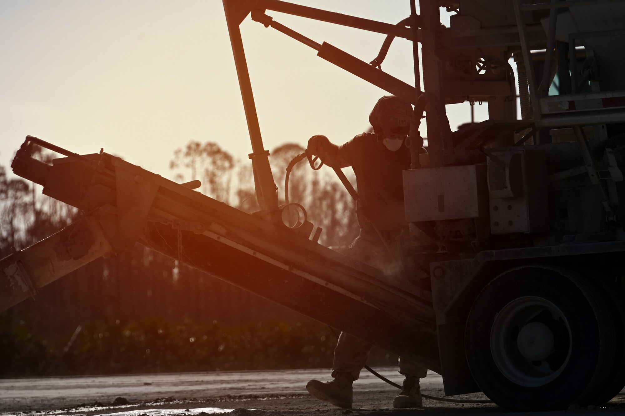 Photo of Airman cleaning cement mixer