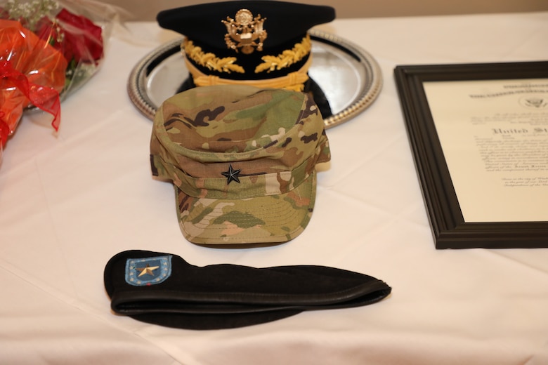 Brig. Gen. Mark Quander was pinned with a set of heirloom insignia that was previously worn by other members of the family. The subdued insignia on his operational camouflage pattern hat adorned Gen. (ret.) Vincent Brooks’ uniform. The rank on the epaulets Quander will wear on his Army service uniform shirt were also worn by Vincent Brooks when he was a brigadier general. The silver star on Quander’s beret was first worn by Brig. Gen. (ret.) Leo Brooks Sr. upon his promotion to brigadier general and then by Vincent Brooks when he pinned on his first star. And, the nameplate worn on Quander’s uniform is the same one worn by his father, the late Lt. Col. (ret.) Francis A. Quander, Jr.