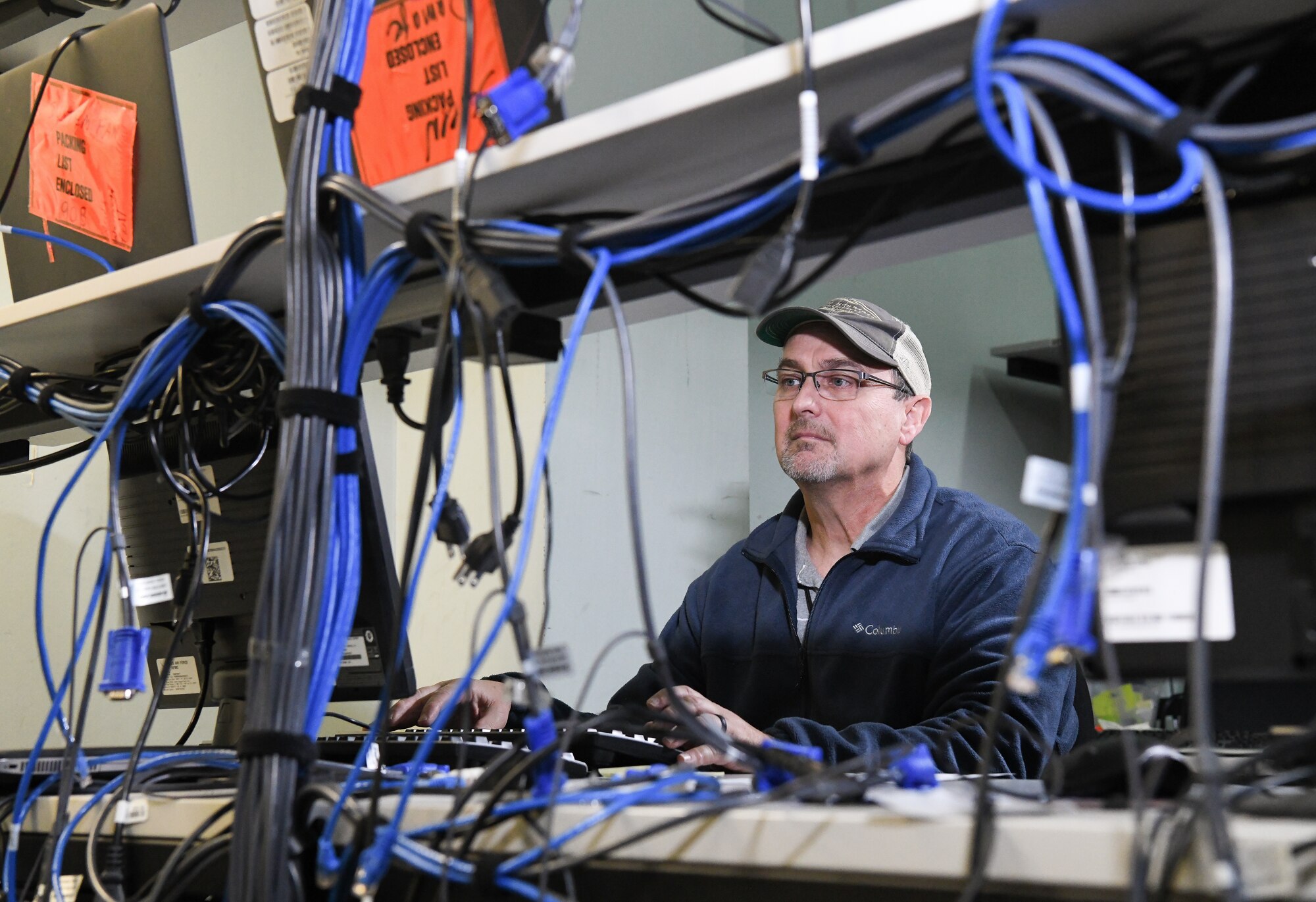 Troy Haywood, lead computer network technician, restages a computer for Non-Classified Internet Protocol Router Network, Dec. 12, 2019, in the PC Staging Area at Arnold Air Force Base, Tenn. Computers must be loaded with required software and necessary security protocols prior to being deployed for use by AEDC team members. (U.S. Air Force photo by Jill Pickett)