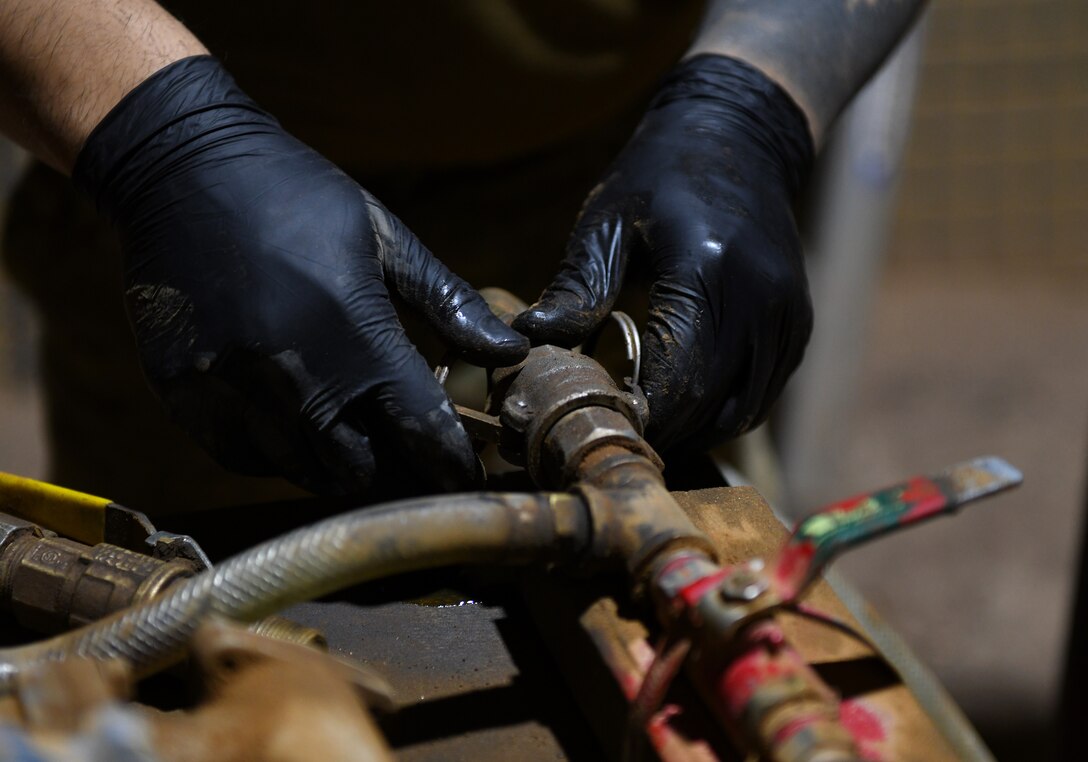 Photo of Airmen performing preventative maintenance on a generator.
