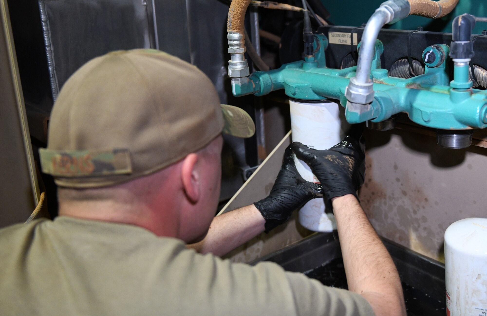 Photo of Airmen performing preventative maintenance on a generator.