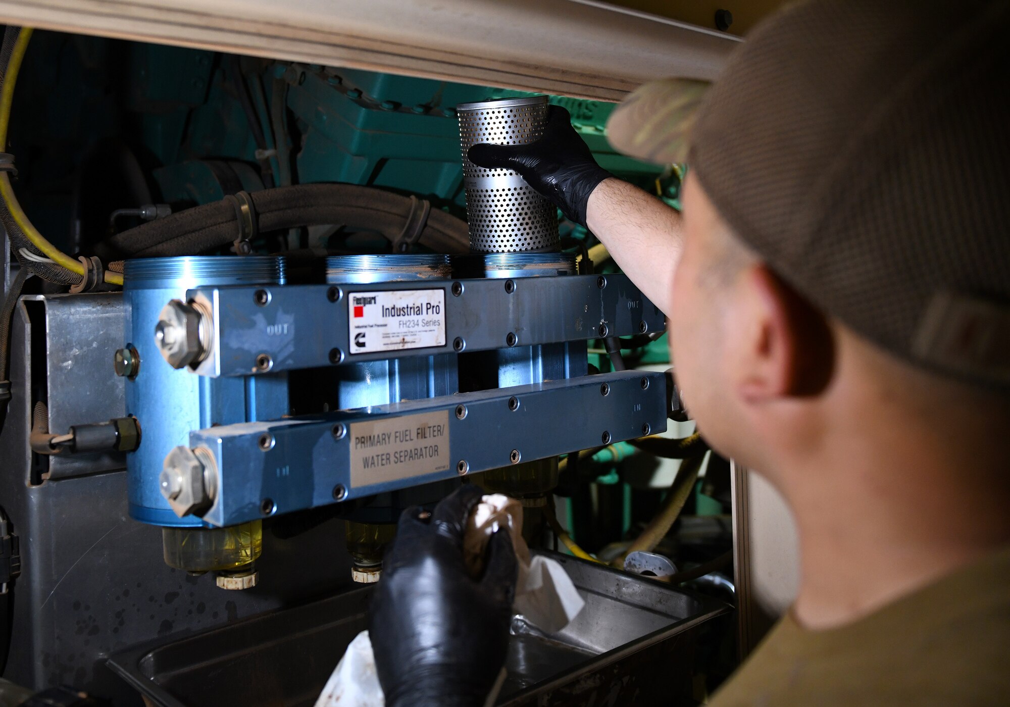 Photo of Airmen performing preventative maintenance on a generator.