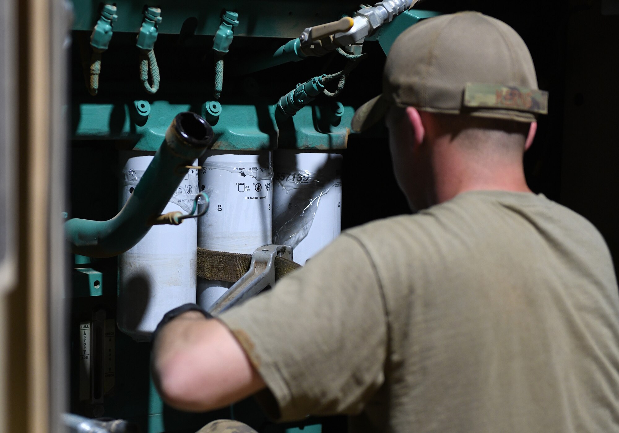 Photo of Airmen performing preventative maintenance on a generator.