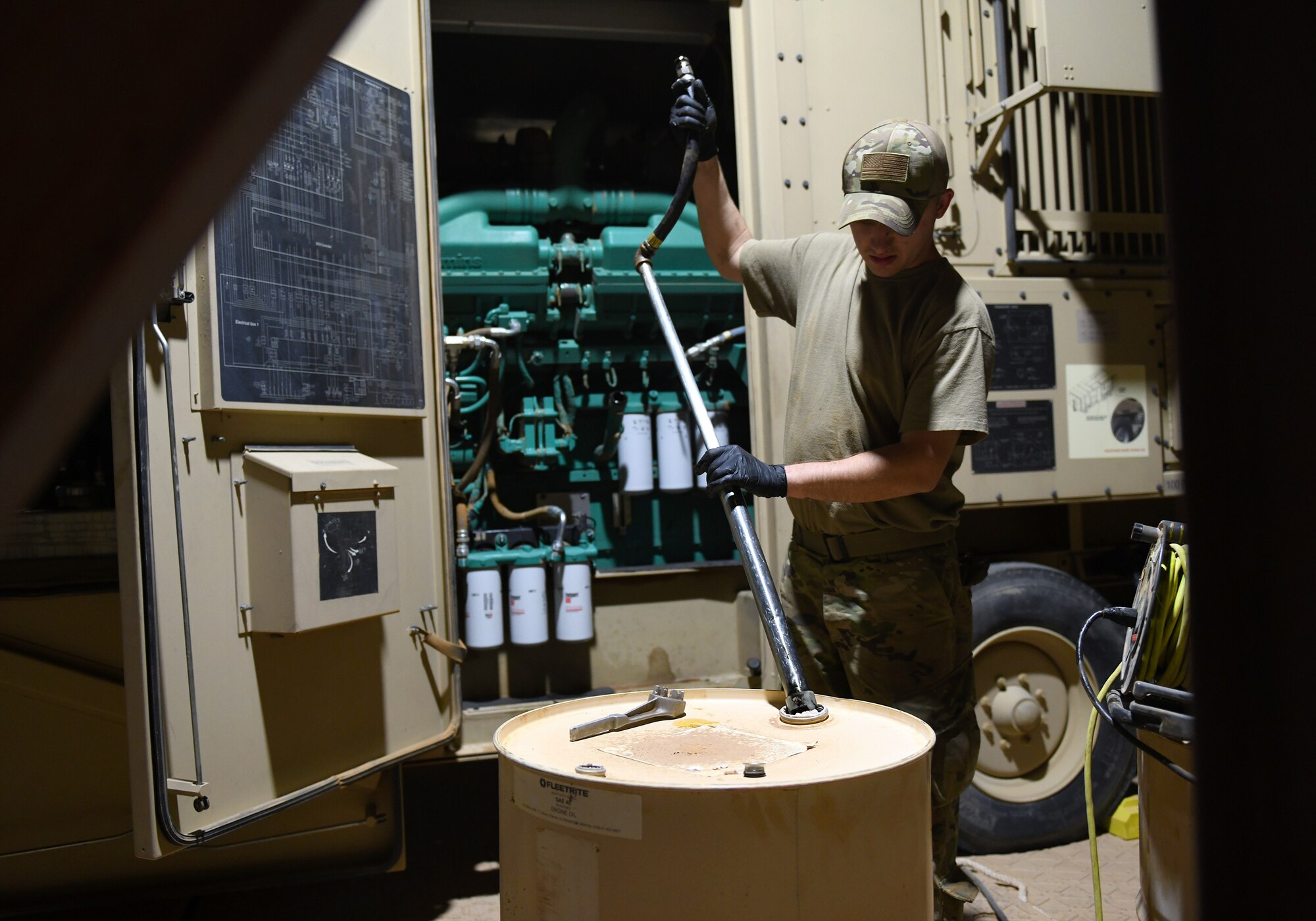 Photo of Airmen performing preventative maintenance on a generator.