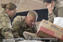 Cpl. Molly Campbell and Cpl. Caleb Creech, UH-60 helicopter repairers, 1107th Theater Aviation Sustainment Maintenance Group, work together to repair a UH-60 helicopter at Camp Buehring, Kuwait, Feb. 11, 2020.