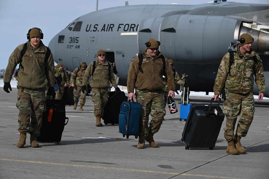 Photo of 119 Wing members walking away from C-17 airctaft on flight line as they return from Exercise Southern Strike.