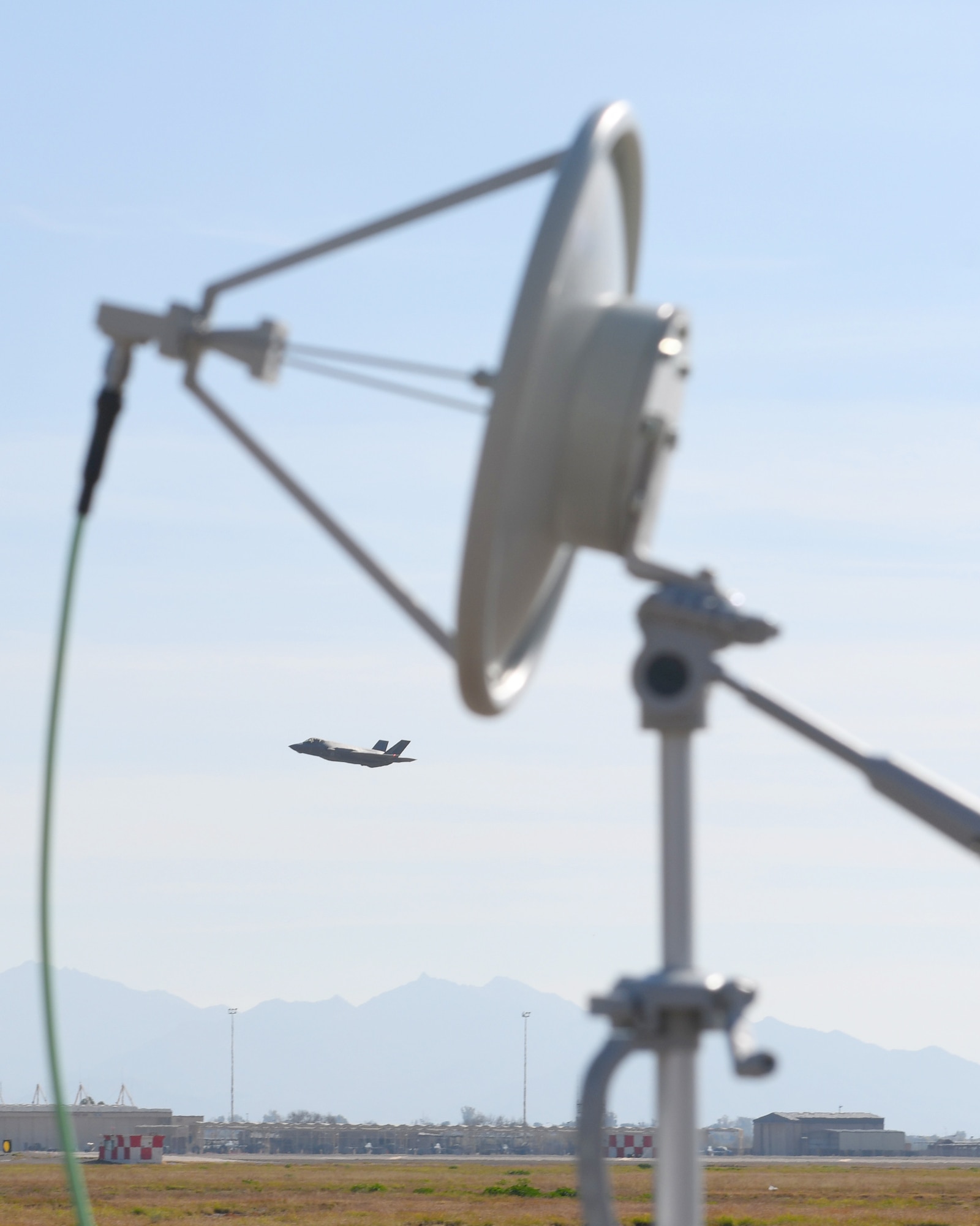 An F-35A Lightning II flies by a prototype threat emitter Jan. 17, 2020, at Luke Air Force Base, Ariz.