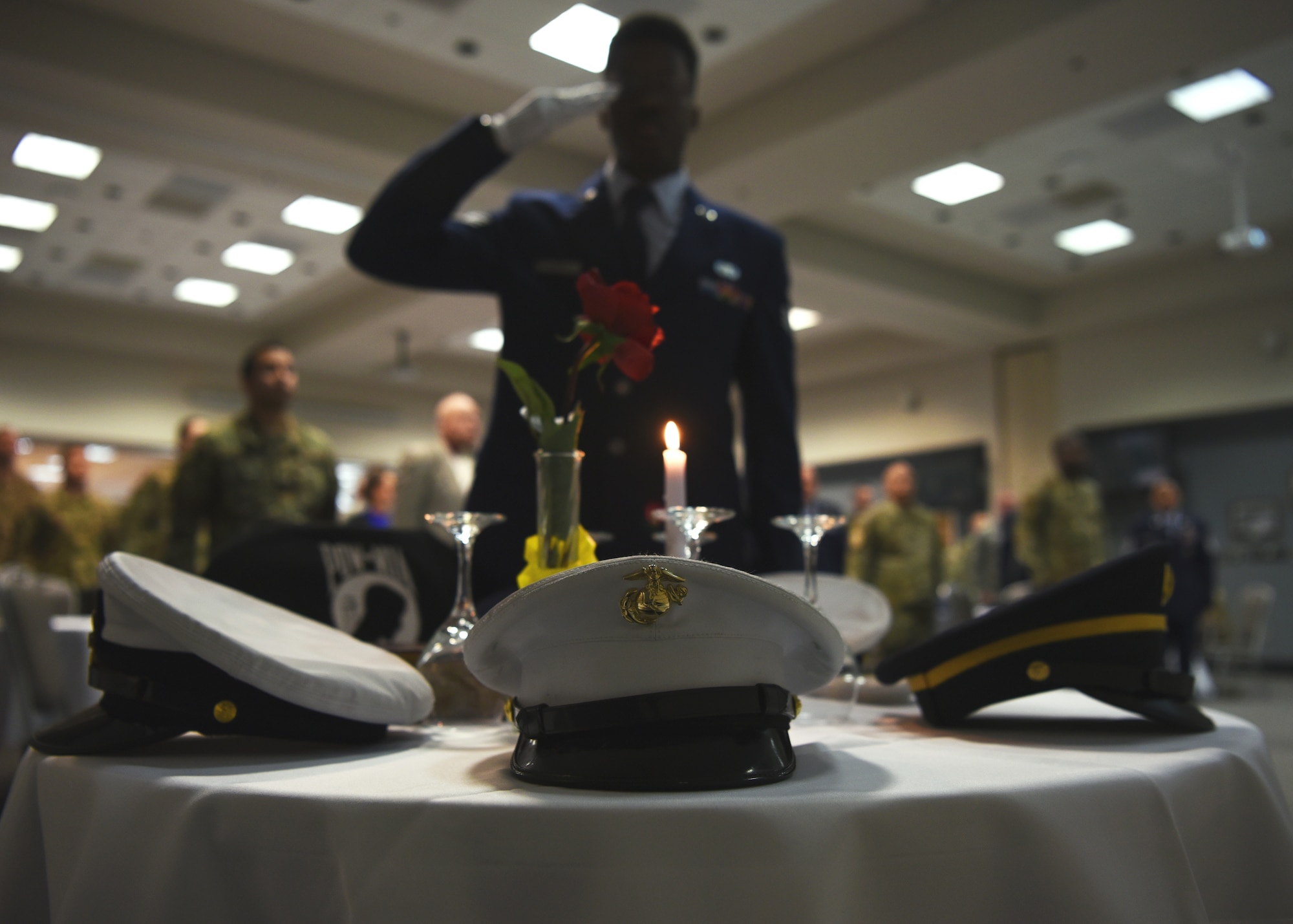 U.S. Air Force Senior Airman Ashley Louis, 17th Logistics Readiness Squadron deployment technician, salutes the POW/MIA table during the Airman Leadership School Graduation Ceremony in the event center at Goodfellow Air Force Base, Texas, Feb. 13, 2020.  Traditionally, ALS graduates set the POW/MIA table at the ceremony. (U.S. Air Force photo by Airman 1st Class Abbey Rieves)