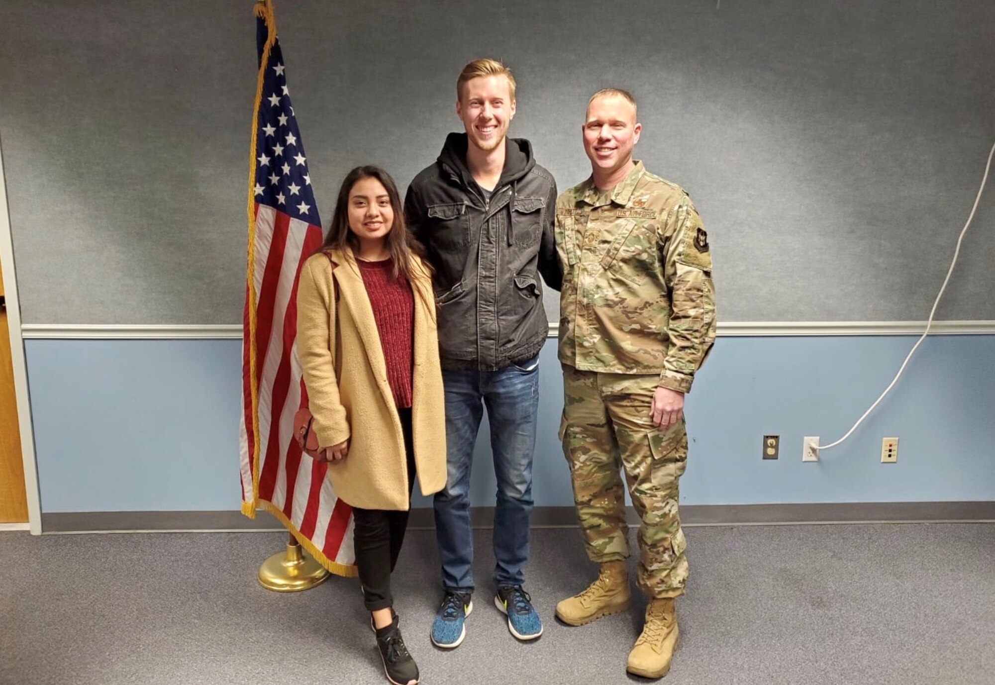 Aiden Tribett, a new recruit in the 419th Fighter Wing, poses with his wife, Gia, and his father, Chief Master Sgt. Brent Tribett from the 67th Aerial Port Squadron, following an enlistment ceremony at Hill Air Force Base, Utah