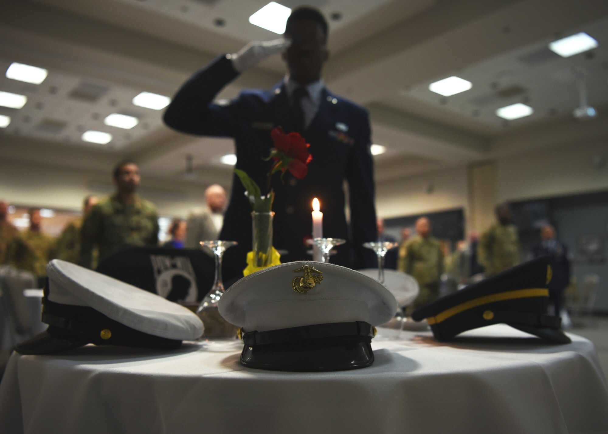 U.S. Air Force Senior Airman Ashley Louis, 17th Logistics Readiness Squadron deployment technician, salutes the POW/MIA table during the Airman Leadership School Graduation Ceremony in the event center at Goodfellow Air Force Base, Texas, Feb. 13, 2020.  Traditionally, ALS graduates set the POW/MIA table at the ceremony. (U.S. Air Force photo by Airman 1st Class Abbey Rieves)