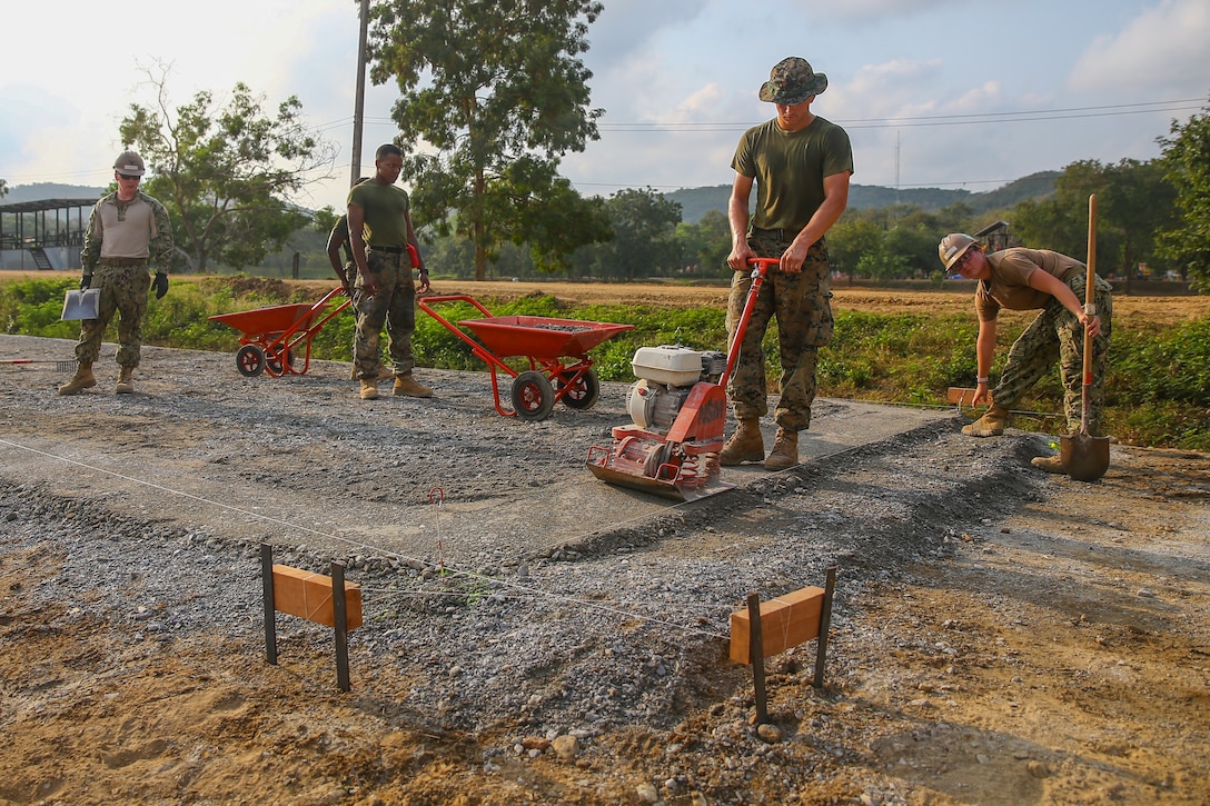 U.S. service members dump, spread and compact fresh gravel during a subject matter expert exchange on Royal Thai Marine Base Sattahip, Kingdom of Thailand, Jan. 23.