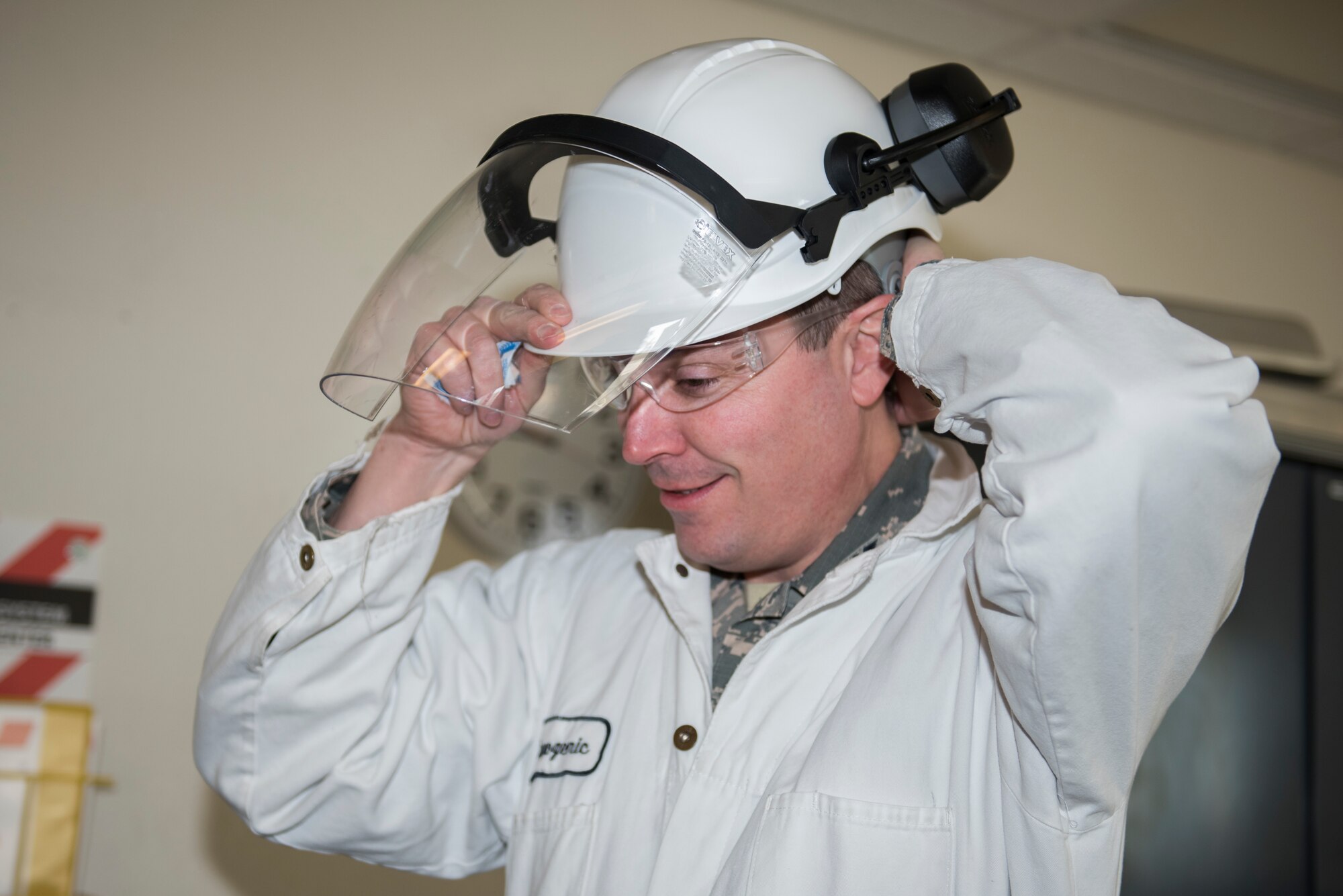 U.S. Air Force Col. Jeffrey Nelson, 60th Air Mobility Wing commander, dons personal protective equipment during a Leadership Rounds visit Feb. 14, 2020, at Travis Air Force Base, California. The Leadership Rounds program provides 60th AMW leadership an opportunity to interact with members of Team Travis and get a detailed view of each mission performed on base. (U.S. Air Force photo by Airman 1st Class Cameron Otte)