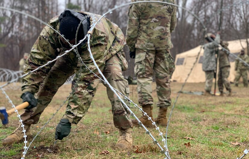 U.S. Army Soldiers assigned to the 53rd Movement Battalion hammer stakes into the ground during an area defense field training exercise at Joint Base Langley-Eustis, Virginia, Feb. 13, 2020.