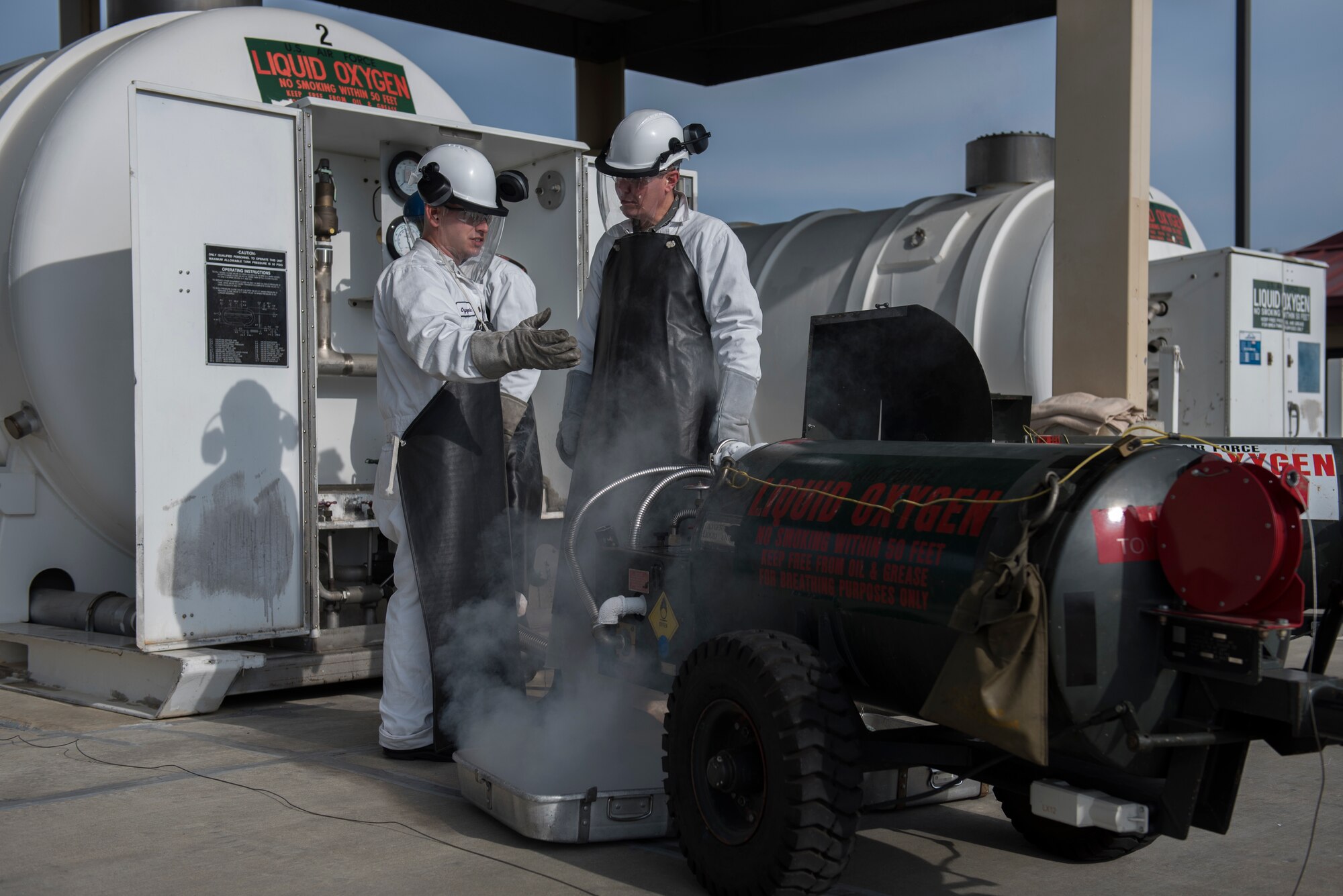 U.S. Air Force Staff Sgt. Adrian Jenkins, left, 60th Logistics Readiness Squadron environmental safety officer, shows Col. Jeffrey Nelson, 60th Air Mobility Wing commander, how to fill a liquid oxygen cart with a cryogenics tank during a Leadership Rounds visit Feb. 14, 2020, at Travis Air Force Base, California. The Leadership Rounds program provides 60th AMW leadership an opportunity to interact with members of Team Travis and get a detailed view of each mission performed on base. (U.S. Air Force photo by Airman 1st Class Cameron Otte)