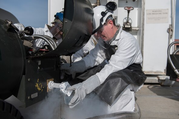 U.S. Air Force Senior Airman Elisha Nwaukoni, left, 60th Logistics Readiness Squadron cryogenics technician, shows Col. Jeffrey Nelson, right, 60th Air Mobility Wing commander, how to extract liquid nitrogen from a liquid oxygen Cart during a Leadership Rounds visit Feb. 14, 2020, at Travis Air Force Base, California. The Leadership Rounds program provides 60th AMW leadership an opportunity to interact with members of Team Travis and get a detailed view of each mission performed on base. (U.S. Air Force photo by Airman 1st Class Cameron Otte)