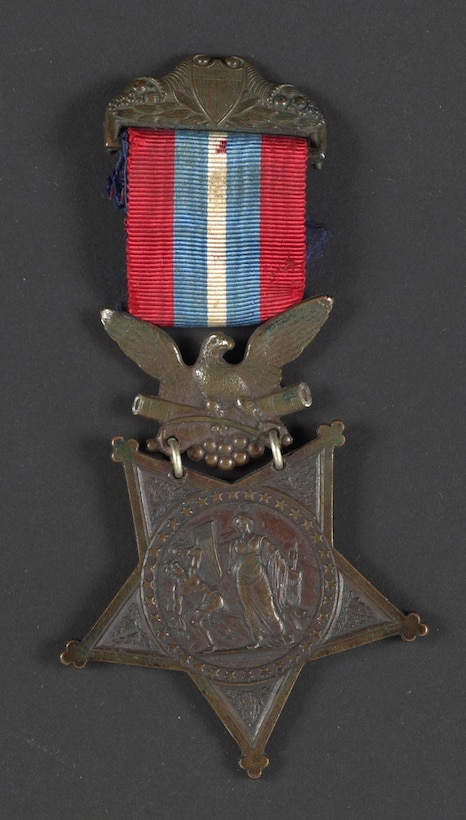 A star medal with an insignia is held to a clasp with a red, white and blue ribbon.
