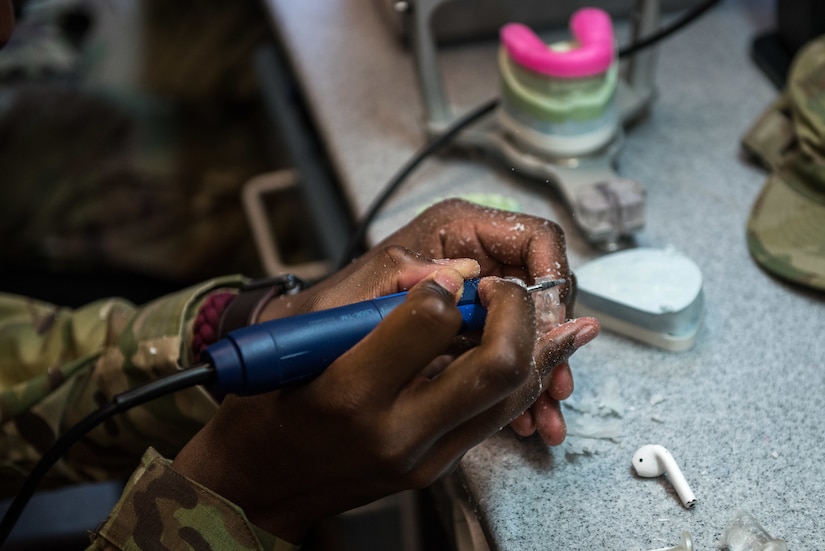 Airman works at the dental laboratory.