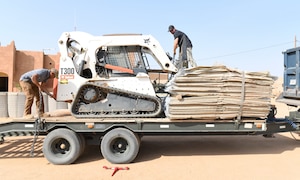 Photo of Airmen delivering protective barriers to help fortify a National Guard of Niger’s compound.