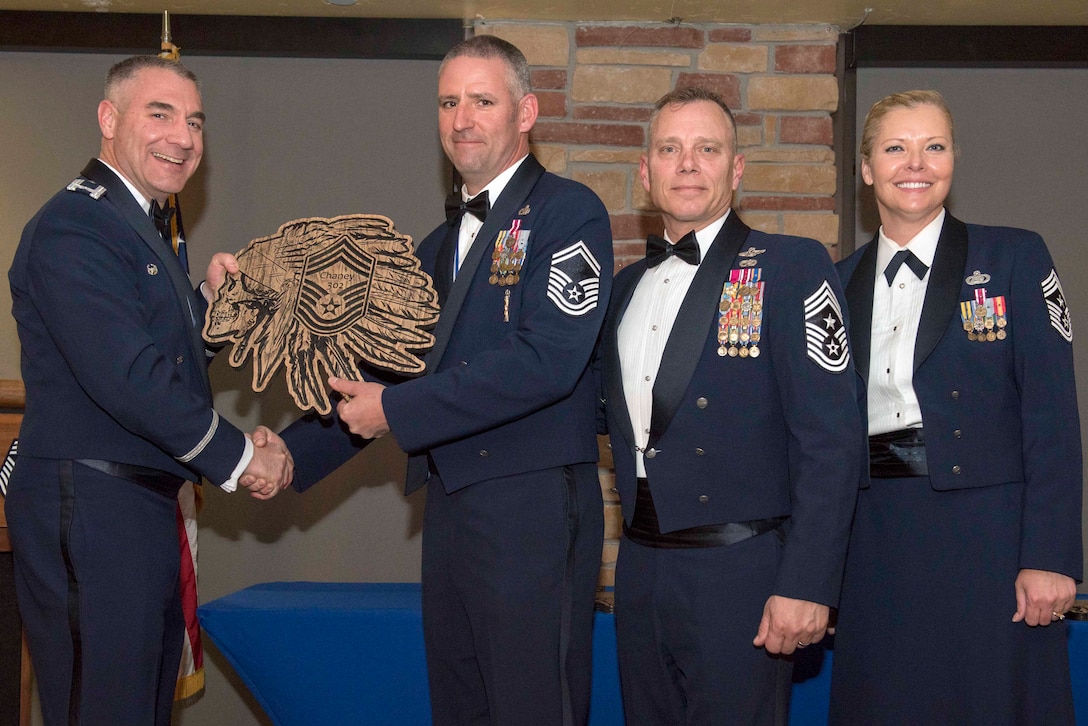 Senior Master Sgt. Travis Chaney, 49th Maintenance Group wing weapons manager, accepts a plaque during the Chief Recognition Ceremony, Feb. 15, 2020, on Holloman Air Force Base, N.M. Eight individuals from Team Holloman were recognized during the formal ceremony and dinner. (U.S. Air Force photo by Staff Sgt. Christine Groening)