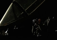 An F-35A Lightning II fighter jet pilot puts on his helmet.