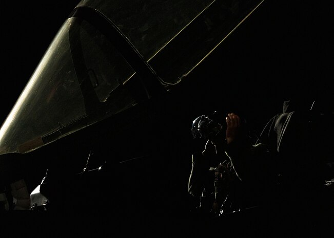 An F-35A Lightning II fighter jet pilot puts on his helmet.