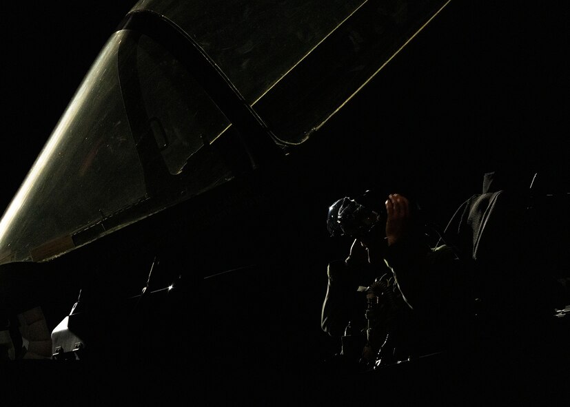 An F-35A Lightning II fighter jet pilot puts on his helmet.
