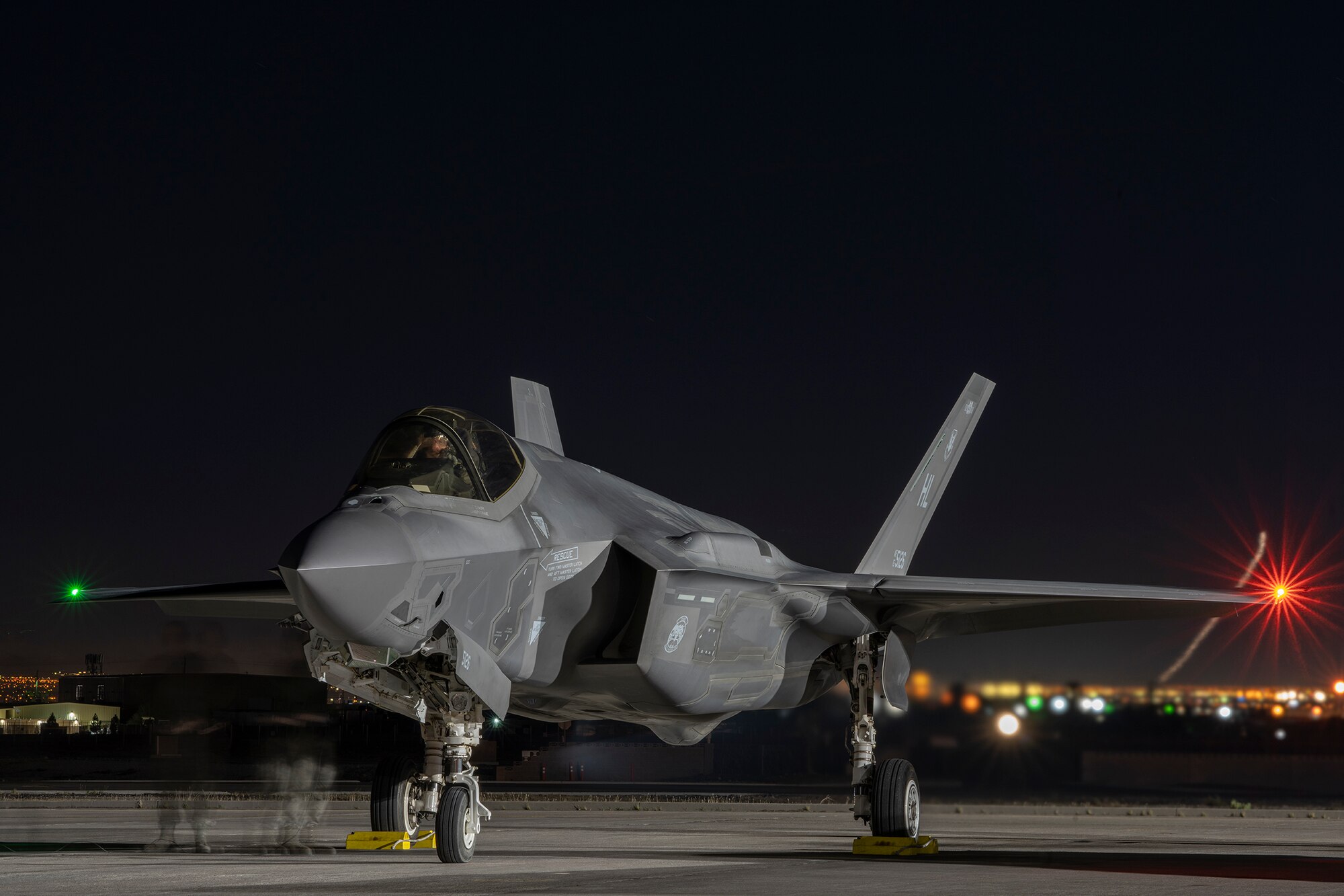 An F-35A Lightning II fighter jet prepares for take-off at night.