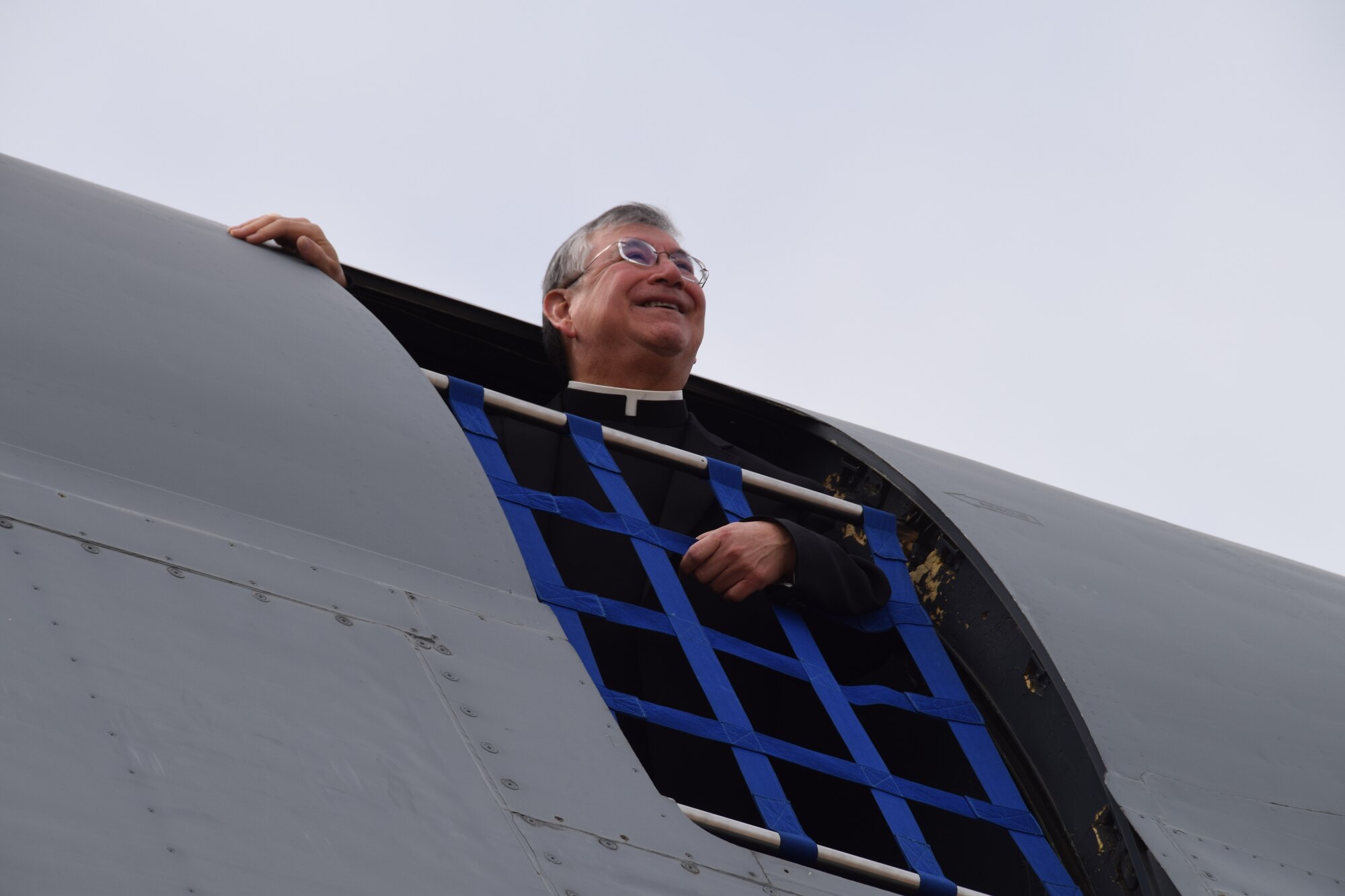 Reverend James A. Tamayo, First Bishop of Laredo and former 433rd Airlift Wing Chaplain looks out of the C-5M Super Galaxy Feb. 16, 2020 at Laredo, Texas.  This was his first time in a C-5M. “To see in Laredo another C-5 visiting our community is great,” said Tomayo. “My prayers have always been with the members of the 4-3-3 and I know the great work that they do.”