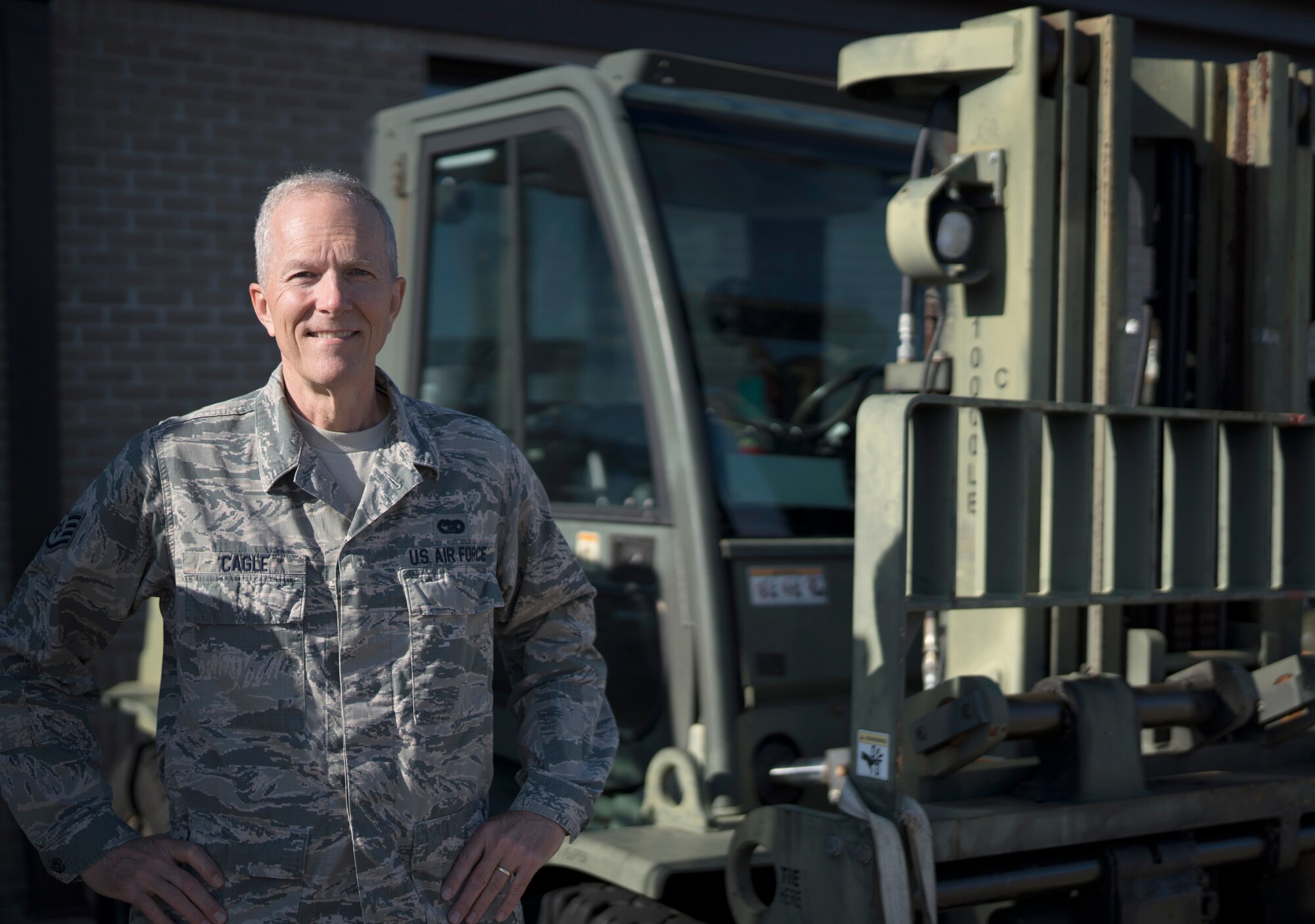 Staff Sgt. Jim Cagle, air terminal operations center controller in the 41st Aerial Port Squadron at Keesler Air Force Base, Miss., poses for a photo in front of a forklift at Keesler Feb. 8, 2020. Prior to his five years with the 403rd Wing, Cagle served as a weapons system officer and fighter pilot in the Louisiana Air National Guard from 1980 to 1993. (U.S. Air Force photo by Senior Airman Kristen Pittman)
