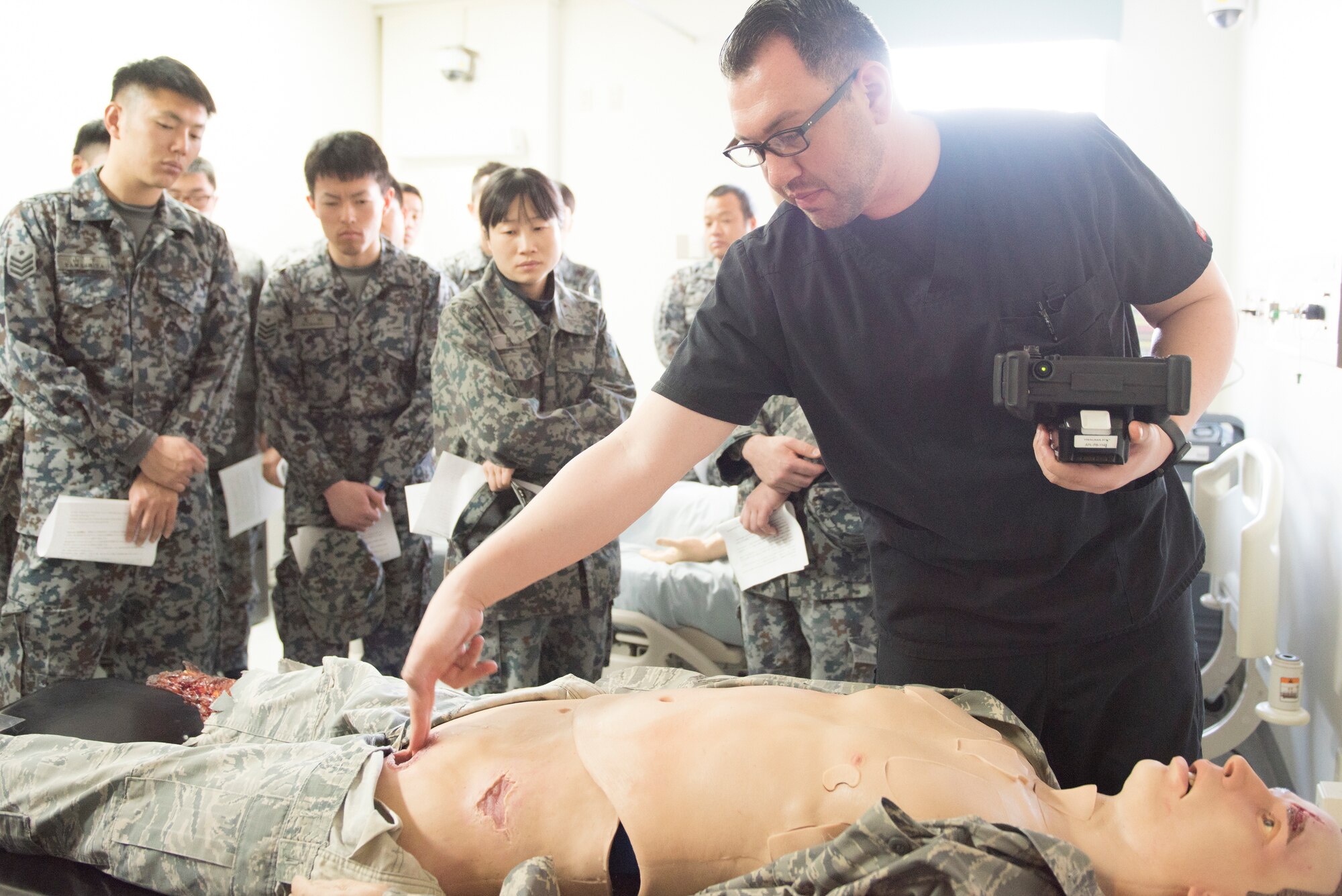 Dominic Trujillo-Hobbs, 374th Medical Group simulation operator, briefs Japan Air Self-Defense Force members on the capabilities of a patient simulator and how it helps with medical education and training, Feb.12, 2020, at Yokota Air Base, Japan.