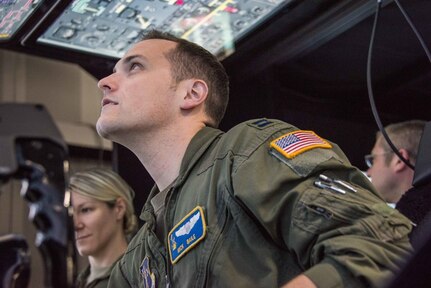 U.S. Air Force Capt. Nicholas Baile, 166th Operations Group pilot, Delaware Air National Guard, troubleshoots a start malfunction in the 166th Airlift Wing flight simulator while Capt. Alexandria Anzur, navigator, sits in the copilot’s seat. In the simulator at New Castle Air National Guard Base, flight crews can try every position: pilot, copilot, flight engineer and navigator, leading to a greater understanding of other crew members’ responsibilities.