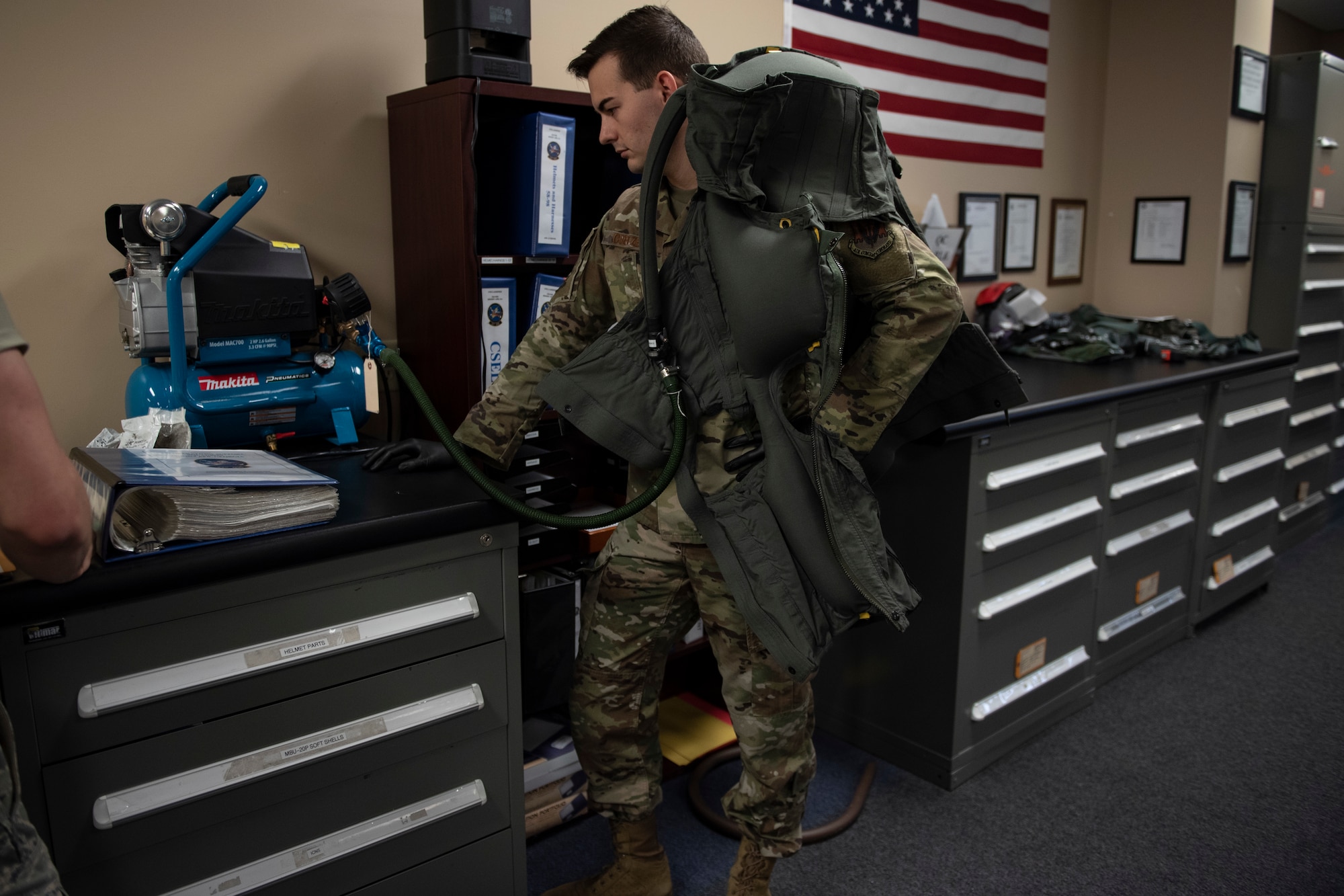 A photo of an airman inflating an Anti-G suit during an inspection.