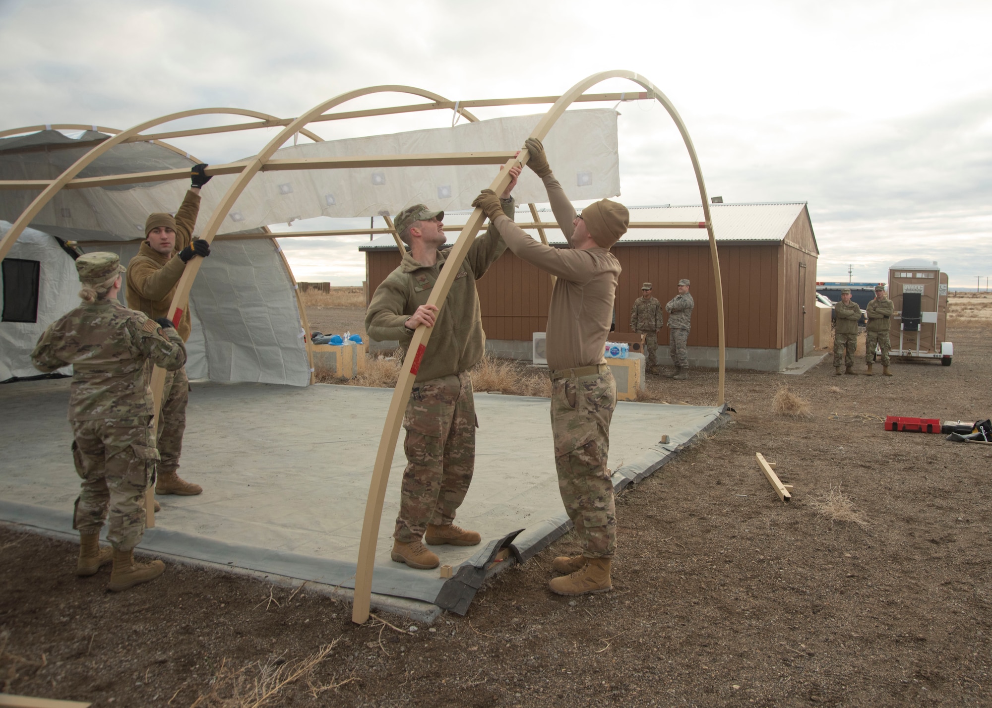 U.S. Air Force 2nd Lt. Doug Jaks, 366th Civil Engineering Squadron chief of operations, assists a group of Airmen in connecting aluminum arches, Jan. 23, 2020, on Mountain Home Air Force Base, Idaho. This training prepares Airmen for obstacles in future deployments. (U.S. Air Force photo by Airman 1st Class Akeem K. Campbell)