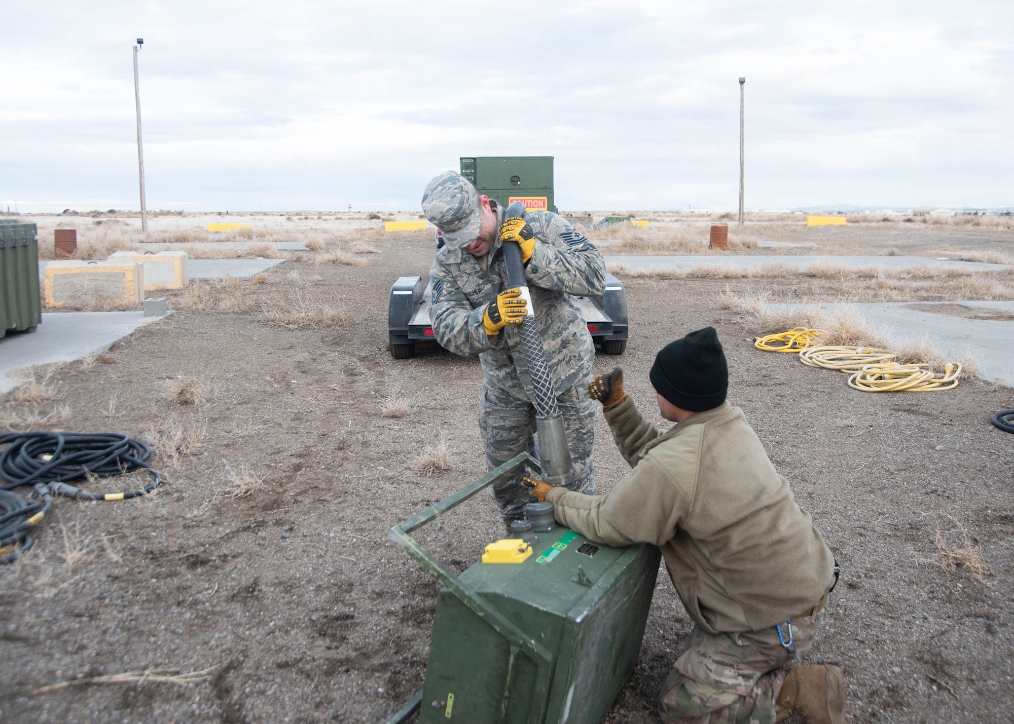U.S. Air Force Tech. Sgt. Chris Archer, 366th Civil Engineering Squadron power production craftsman, assists Staff Sgt. Kevin Rivera Calzada, 366th Civil Engineering Squadron power production journeyman in setting up a remote power source, Jan. 23, 2020, on Mountain Home Air Force Base, Idaho. This is part of the structural build-up of the Base Emergency Engineer Force training which produces multicapable Airmen. (U.S. Air Force photo by Airman 1st Class Akeem K. Campbell)