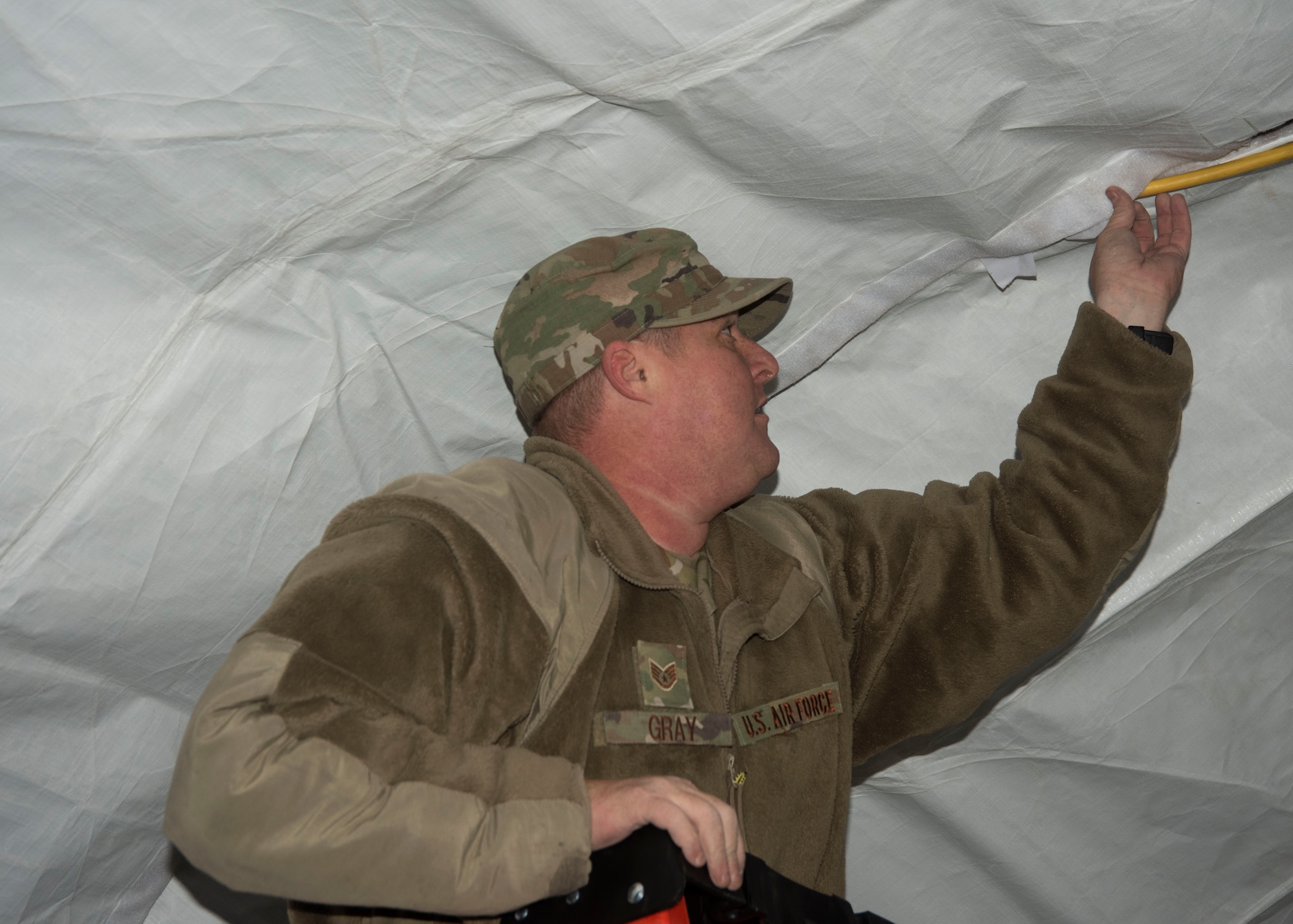 U.S. Air Force Staff Sgt. James Gray, 366th Civil Engineering Squadron structural craftsman, secures the electrical line inside the tent, Jan. 23, 2020, on Mountain Home Air Force Base, Idaho. This training prepares Airmen for obstacles in future deployments. (U.S. Air Force photo by Airman 1st Class Akeem K. Campbell)