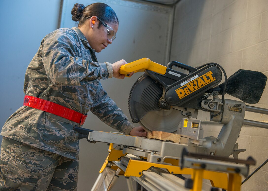 Airman Basic Starr Figueroa, 103rd Logistics Readiness Squadron traffic management specialist, operates an arm saw at Bradley Air National Guard Base, East Granby, Conn. Feb. 8, 2020. Traffic management specialists construct custom shipping containers to Air Force specifications for safe delivery of certain pieces of equipment, including C-130H wheels. (U.S. Air National Guard photo by Staff Sgt. Steven Tucker)