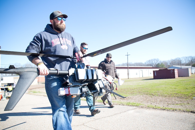 U.S. Army Engineer Research and Development Center-Environmental Laboratory’s Unmanned Aircraft Systems team members Barry Barnett, Kenneth Matheson and Shea Hammond prepare the Vapor 55, a UAS that weighs just under 55 pounds and carries both the LiDAR sensor and 42MP camera, to capture Geographic Information System installation data.  )