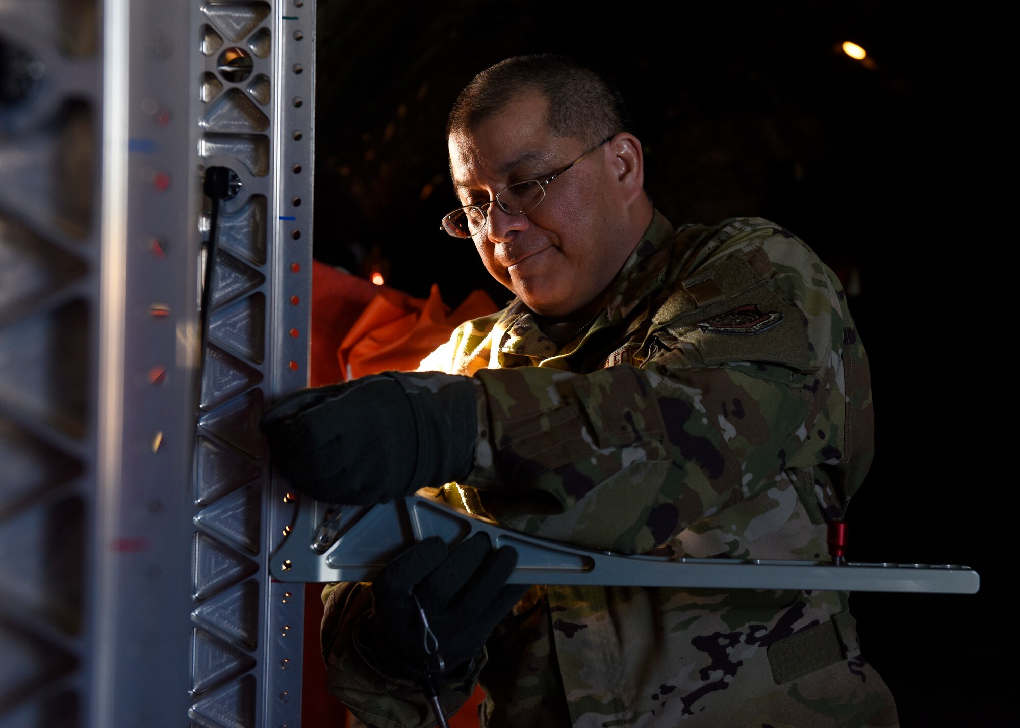 U.S. Air Force Lt. Col. David Hernandez, 43rd Aeromedical Evacuation Squadron chief flight nurse, prepares a litter stanchion system on a Fairchild Air Force Base KC-135 Stratotanker prior to an aeromedical evacuation mission at Travis Air Force Base, California, Feb. 11, 2020. Training consisted of familiarization of the KC-135 airframe for emergency evacuation procedures, in-flight medical emergency simulations, aircraft emergency simulations and how-to best organize medical equipment for both Fairchild and Travis Airmen in order to qualify for semi-annual requirements. (U.S. Air Force photo by Senior Airman Lawrence Sena)