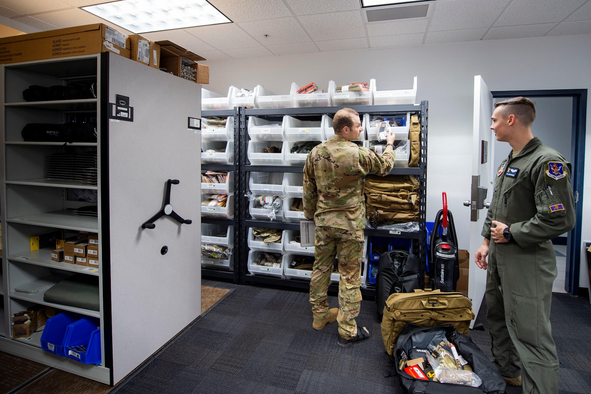 Photo of an Airman showing another Airman equipment.