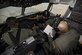 Two Airmen sit in a boom operator box of a KC-10.