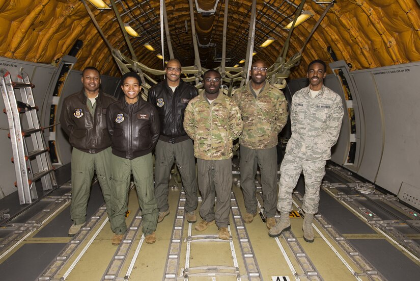 A group of Airmen posing for a photo on an aircraft.