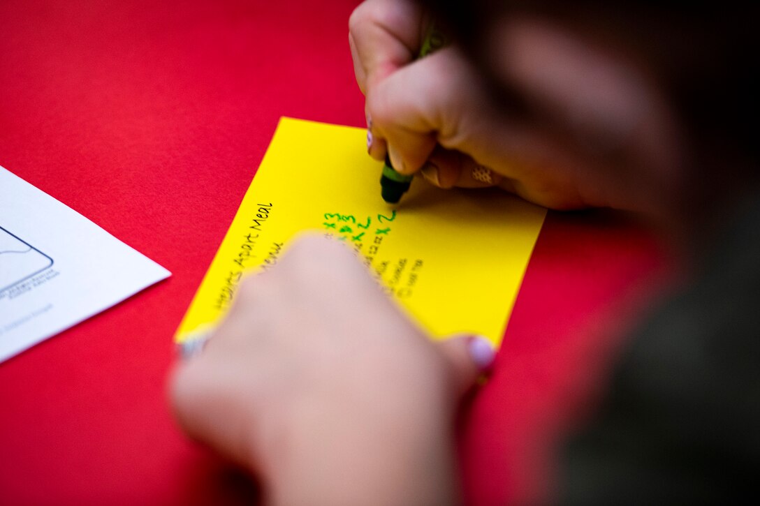 Photo of spouse writing on a meal card.