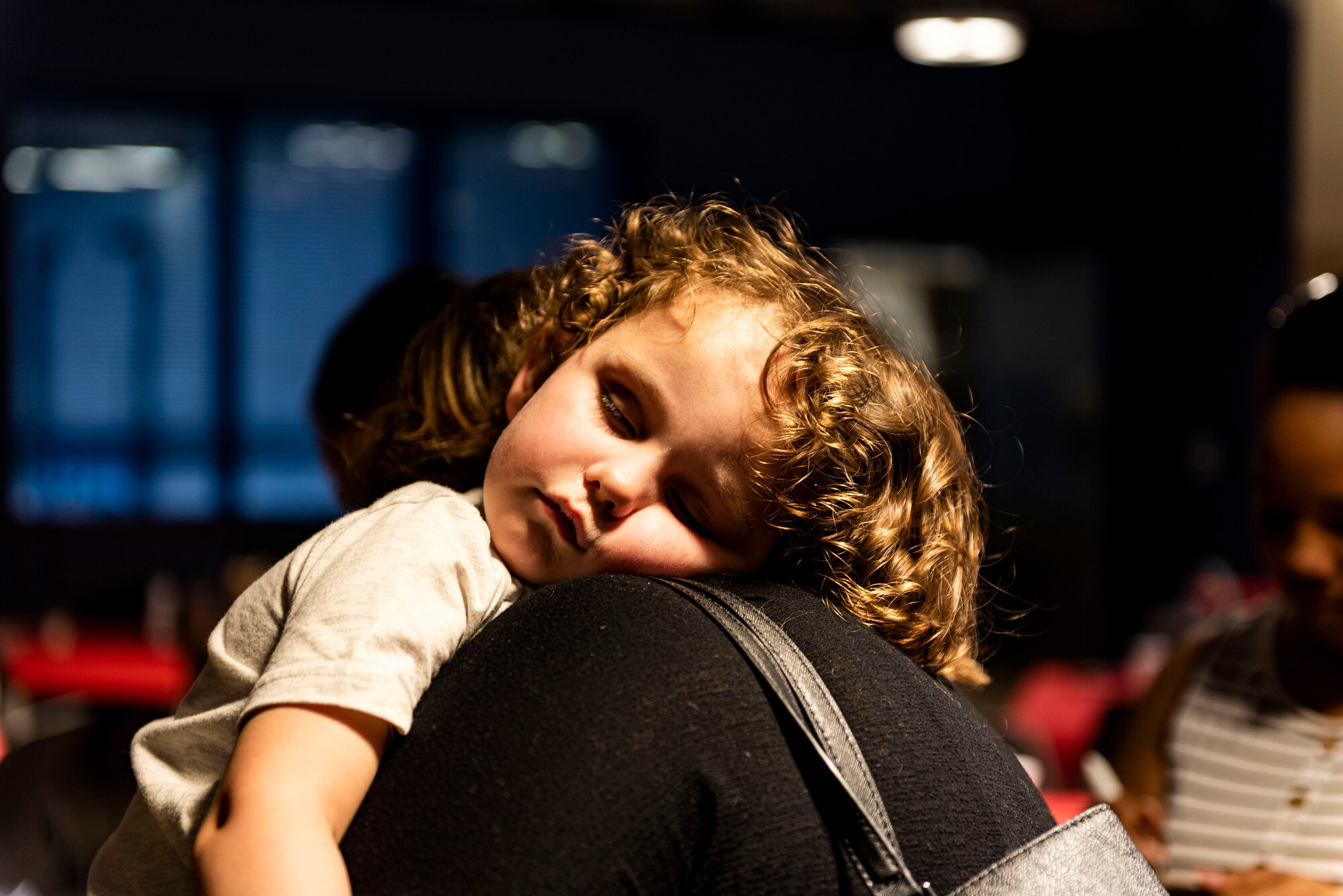 Photo of a child resting on his mom's shoulder.