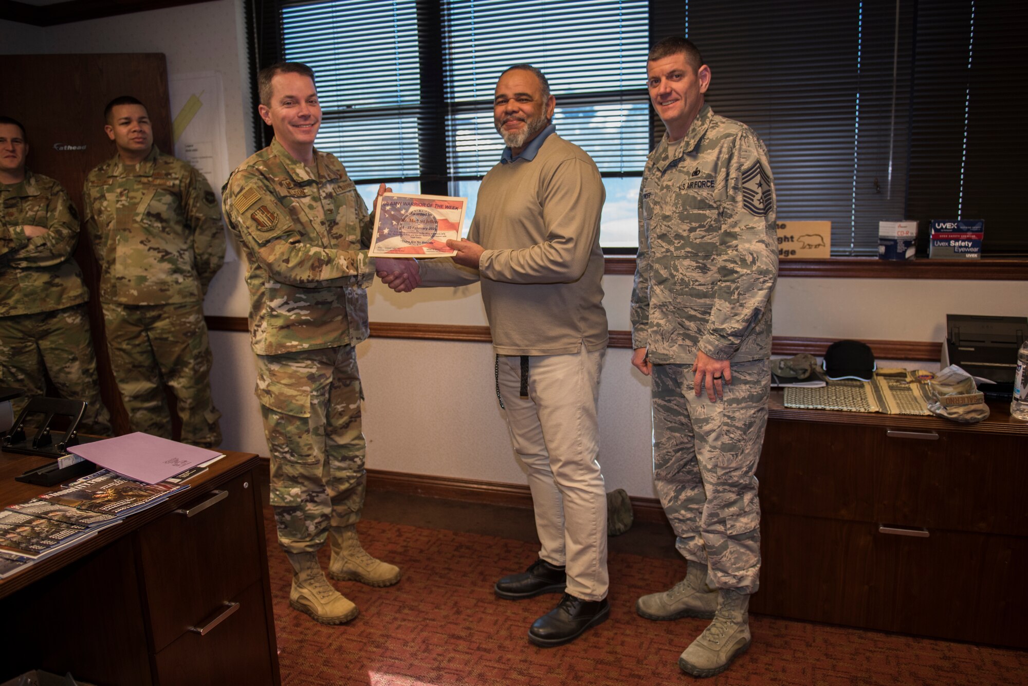 U.S. Air Force Col. Jeffrey Nelson, left, 60th Air Mobility Wing commander, and Chief Master Sgt. Derek Crowder, right, 60th AMW command chief, recognize Michael Jeffery, center, 60th AMW occupational safety and health specialist, Feb. 18, 2020, at Travis Air Force Base, California. Jeffery was the Warrior of the Week from Feb. 16-22. The program recognizes Airmen and civilians who have made significant contributions to their units. (U.S. Air Force photo by Airman 1st Class Cameron Otte)
