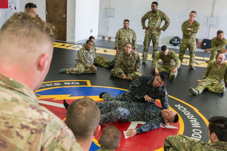 Koku Jieitai (Japan Air Self-Defense Force) Staff Sgt. Hiroki Nishikawa and Staff Sgt. Shiji Miyahara, Base Defense Development Training squadron instructors, demonstrate combative maneuvers to Royal Australian Air Force, U.S. Air Force, and Koku Jietai (JASDF) personnel during Pacific Defender 20-1 at the Pacific Regional Training Center near Andersen Air Force Base, Guam, Feb. 9, 2020.