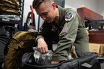 Photo of an Airman packing issued equipment into a bag.