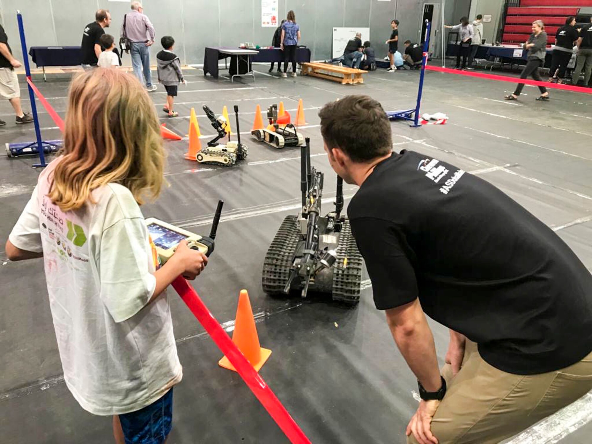 Capt. Paul Underwood, 379th Expeditionary Civil Engineering Squadron explosive ordnance disposal flight commander, shows a student how to operate a bomb defusal robot at American School of Doha’s Maker Faire in Doha, Qatar, on Jan. 25, 2020. The faire is a Science, Technology, Engineering, Arts and Mathematics Builder’s Day where 500 students from more than 80 countries and 10 local schools compete in robotics events and learn about robotic platforms.  (Courtesy Photo)